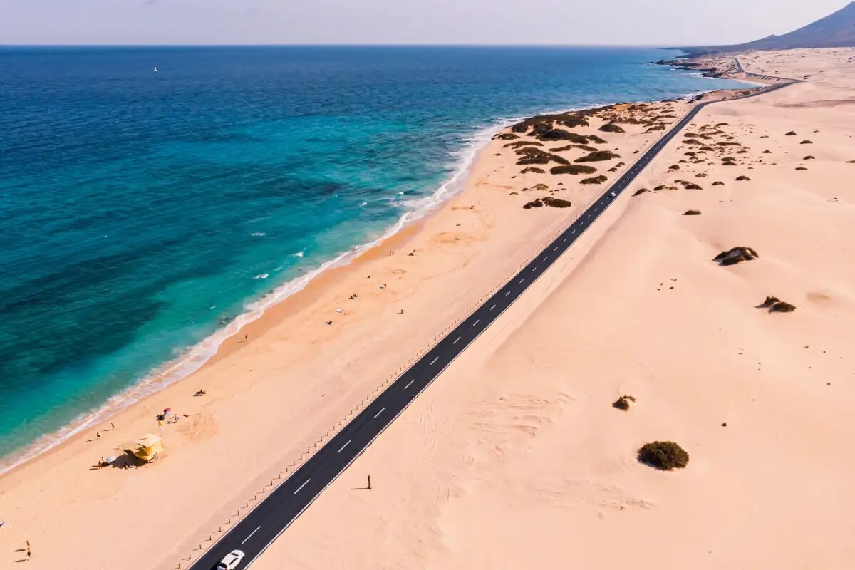Route FV-1 longeant les dunes et la plage au sud de Corralejo.